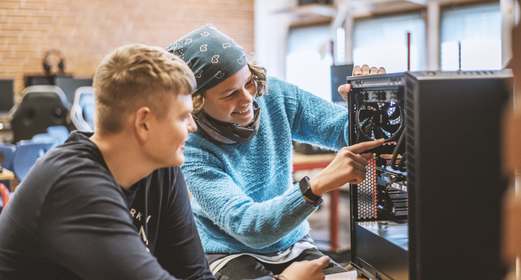 To elever undersøger computerens indre komponenter sammen. 